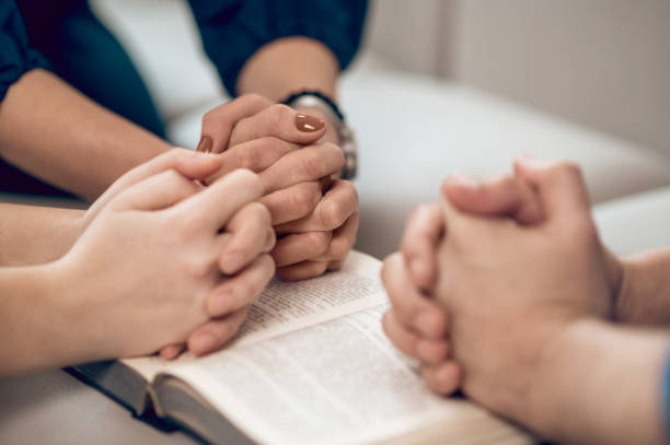 istock Close up picture of hands while praying 1390636707