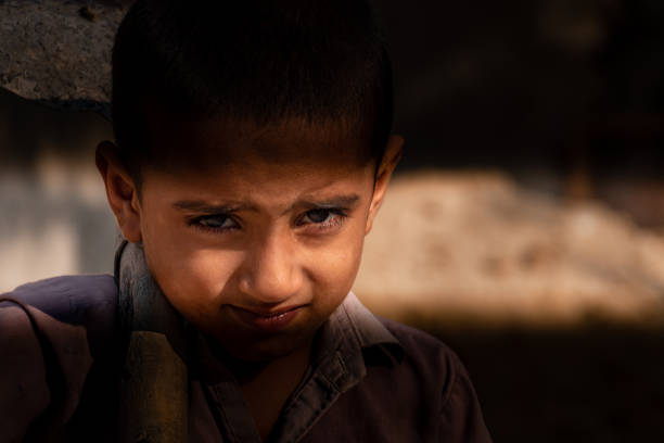istock child boy sitting holding a shovel on a construction site 1390641548