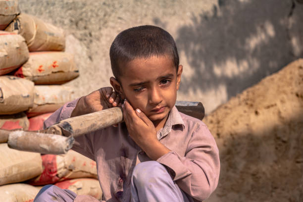 istock child boy sitting holding a shovel on a construction site 1390641559