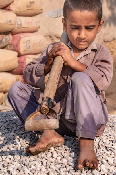 istock child boy sitting holding a shovel on a construction site 1390641569
