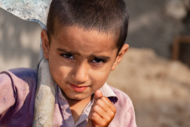 istock child boy sitting holding a shovel on a construction site 1390641603