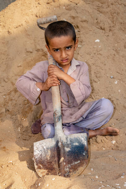 istock child boy working with the shovel on a construction site 1390641639
