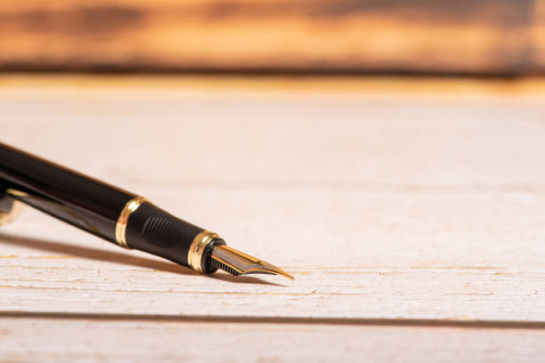 istock Fountain pen, beautiful fountain pen on a rustic wooden surface, selective focus. 1390641661