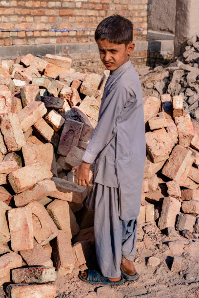 istock a child boy holding a brick in hand on working on a construction site 1390642235