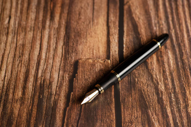 istock Fountain pen, beautiful fountain pen on a rustic wooden surface, selective focus. 1390642769