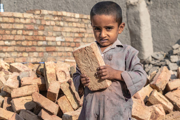 istock a child boy holding a brick in hand on working on a construction site 1390643320