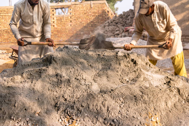 istock labor workers mixing cement and stone crush 1390643461