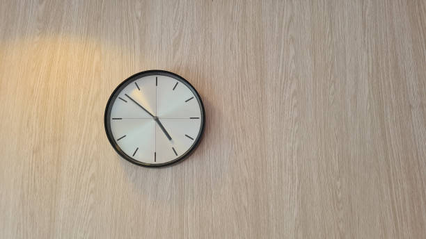istock Clock on a brown wooden wall 1390645052