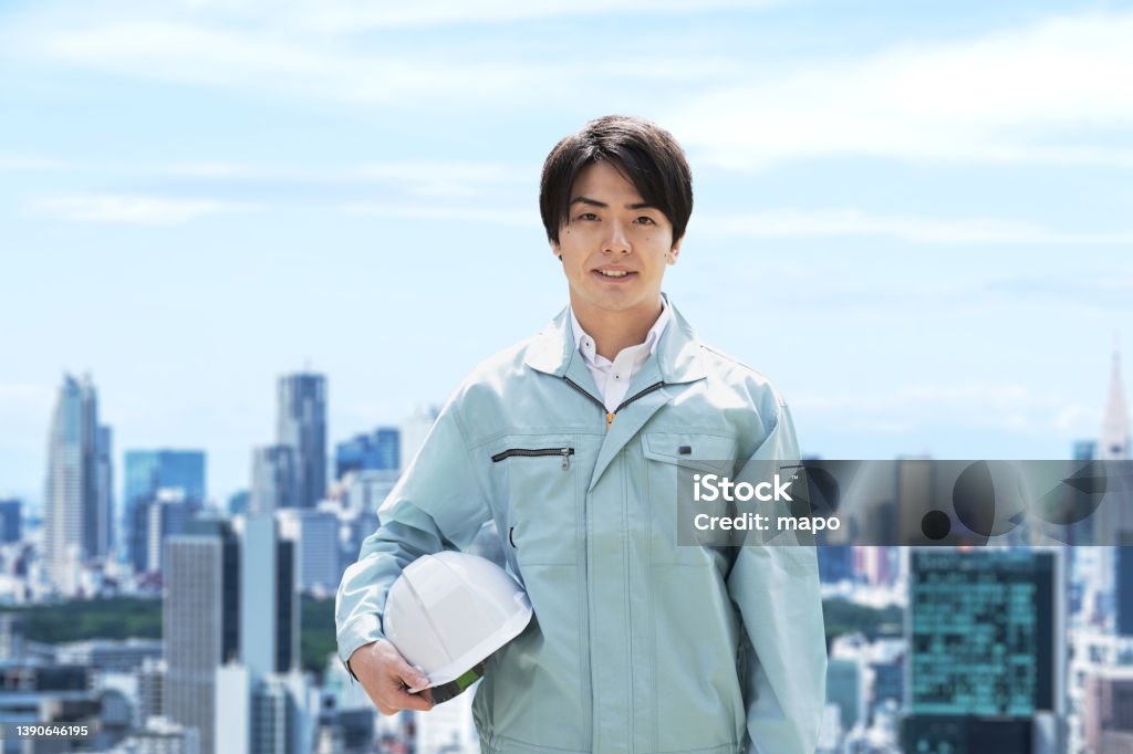 Construction workers against the backdrop of the city Coveralls Stock Photo