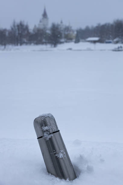 istock a metal thermos with an open lid stands on a snow 1390649492
