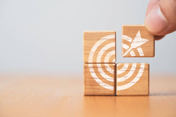 istock Hand holding and assemble target board which print screen wooden block cube for create and setup business objective target concept. 1390651387