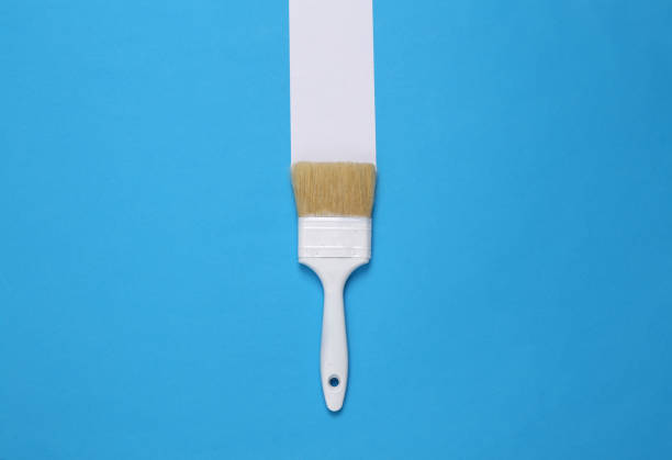 istock Paint brush with white stripe on a blue background. Minimal layout. Top view 1390653633