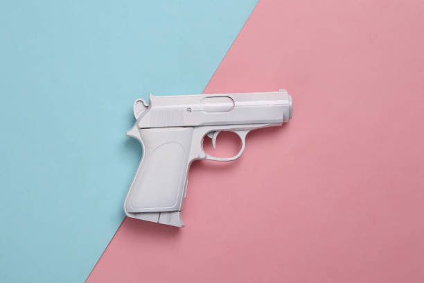 istock White pistol on a blue-pink pastel background. Minimal, creative layout, top view 1390653634