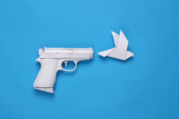 White gun with origami dove on a blue background. Minimal, creative layout, say no war