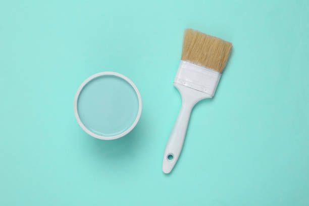 istock Can of paint with paintbrush on turquoise background 1390653697