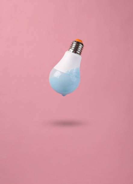 istock Levitating light bulb with dripping turquoise paint on a pink background. Minimal creative layout. Concept art. 1390653698