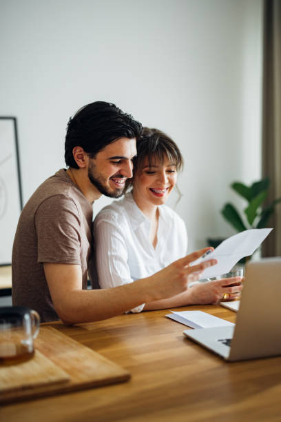 istock Happy Couple Paying Bills at Home 1390654300
