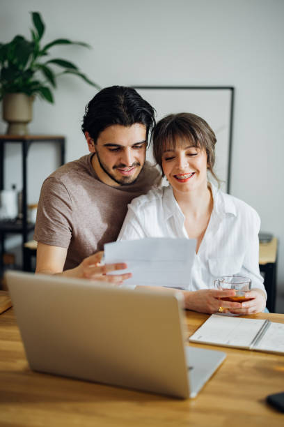 istock Smiling Couple Paying Bills at Home 1390654302