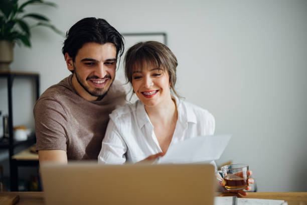 istock Smiling Couple Paying Bills at Home 1390654307
