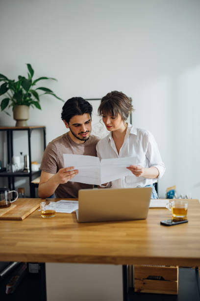 istock Smiling Couple Paying Bills at Home 1390654319