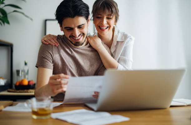 istock Smiling Couple Paying Bills at Home 1390654874