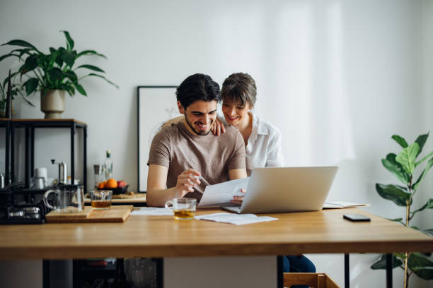istock Smiling Couple Paying Bills at Home 1390654875