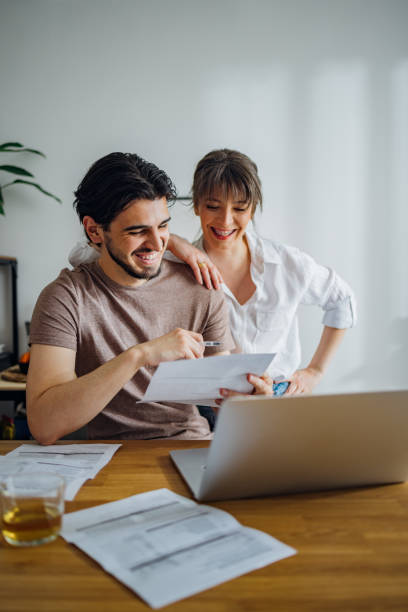 istock Smiling Couple Paying Bills at Home 1390654890