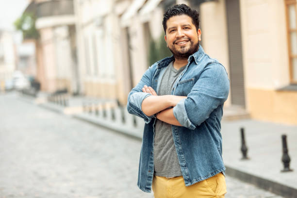 istock Confident smiling hispanic man looking at camera in city 1390655437