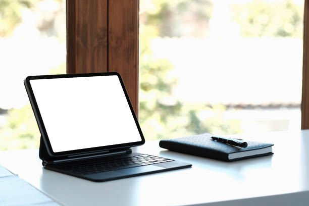 istock mockup image of black digital tablet pc with blank desktop white screen on working space at home office 1390656728