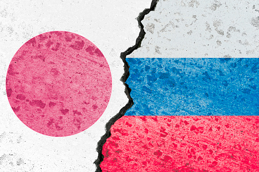 Russia flag and Japan flag print screen on crack wall for business competition and military war conflict between both countries.