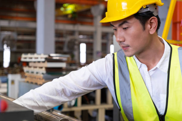 istock Selective focus at Asian men engineer supervisor, wearing safety equipment. While doing audit for quality and safety control inside of factory area. With blurred background of heavy machine. 1390659634