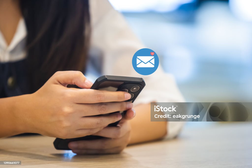woman using smartphone with notification email icon, message media network digital online information. E-Mail Stock Photo