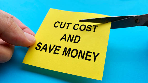 istock Scissors that cut yellow notepad with cut cost and save money text on blue background. Spending concept 1390661611