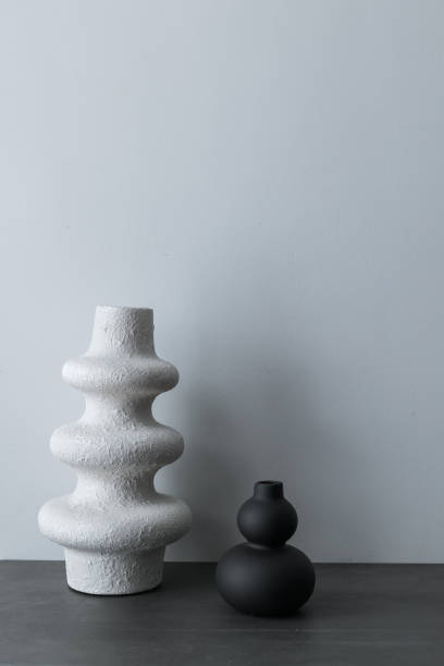 istock Home interior with decor elements. Black photo frame, white and black handmade decorative vases, interior decoration 1390662430