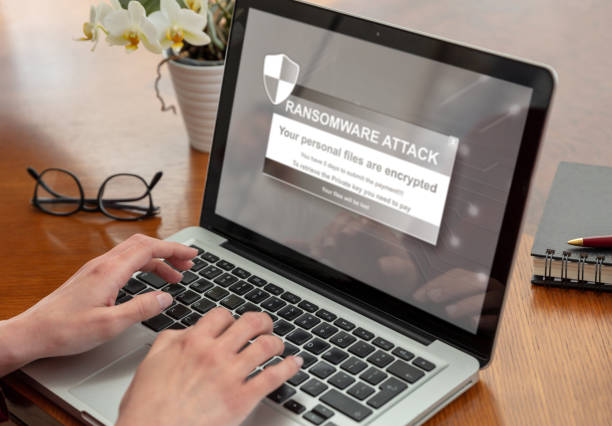 istock Ransom ware, Cyber attack. Warning message on a computer screen. Woman work with a laptop. 1390663573