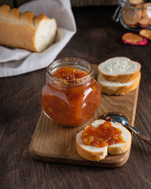 chutney de rmango casero en frasco de vidrio sobre fondo de madera. enfoque selectivo. vertical - chutney jar tomato preserved fotografías e imágenes de stock