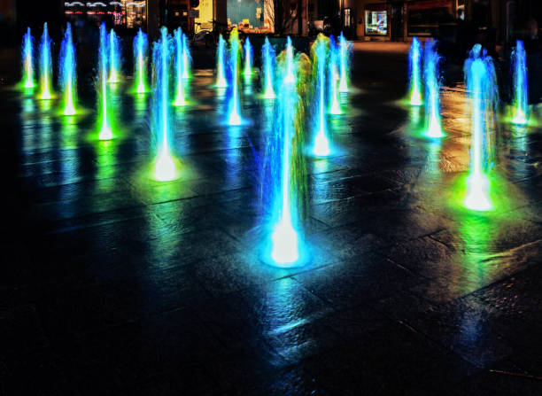 Illuminated waterspout fountain at night stock photo