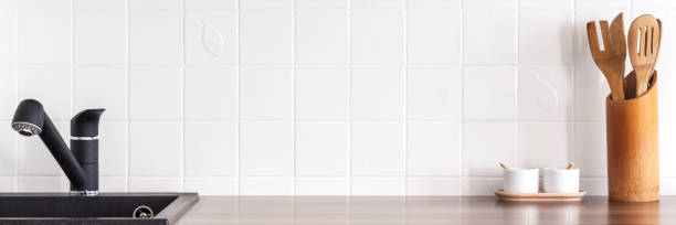 istock Industrial kitchen. White ceramic tiles as copy space. Black kitchen faucet. 1390668178