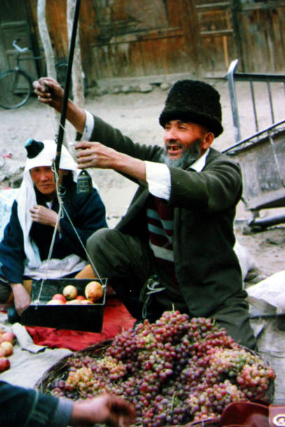 The fruits in Xinjiang is famous and abundant.Fruit farmers in Hotan sell fruit and use old steelyard. Film taken in 1996, Yutian County, Hotan Region, southern Xinjiang