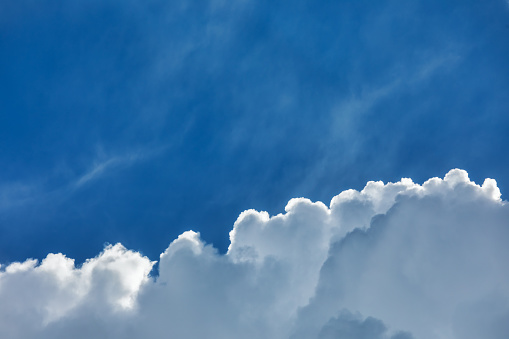 Cloud with a silver lining against blue summer sky - natural background with copy space