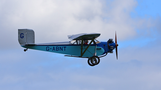 Ickwell, Bedfordshire, England - September 06, 2020: Vintage 1931 Civilian Coupe 02 G-ABNT  aircraft in flight  with blue sky and clouds.