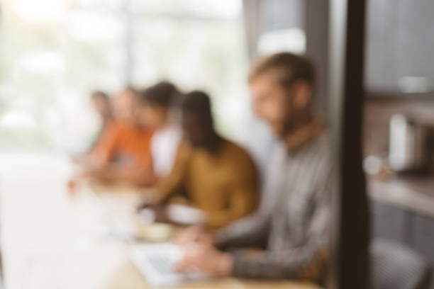 istock blurry image of employees sitting at a desk in a coworking cente 1390673216