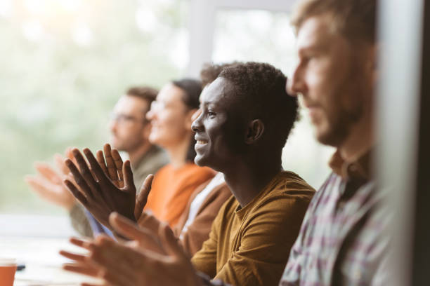 istock group of happy employees applauding while sitting at the same ta 1390673248