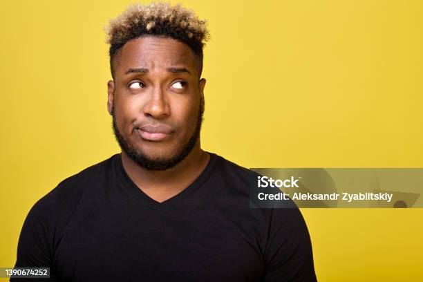 Darkskinned Man With Beard With Smirk On His Face Looks To Side In Disapproval Stock Photo - Download Image Now