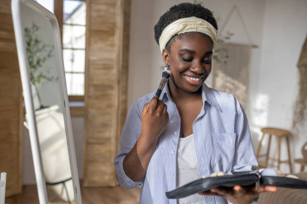 istock African woman near the mirror doing make up 1390674372