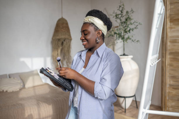 istock African woman near the mirror doing make up 1390674374