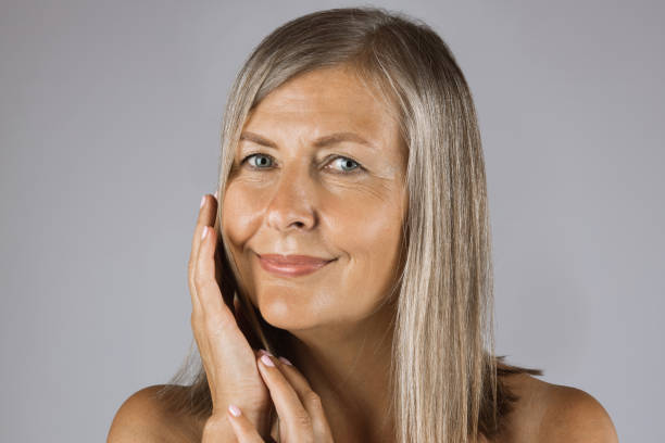 istock Mature woman with bare shoulders touching gently her cheek 1390674402