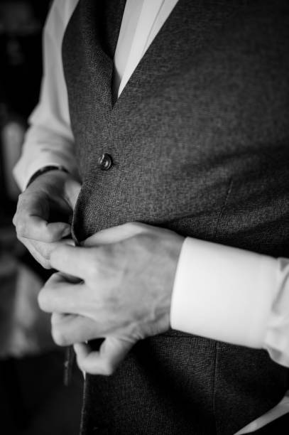 istock The man fasten a button on his jacket. The groom fasten a button on his jacket 1390674434