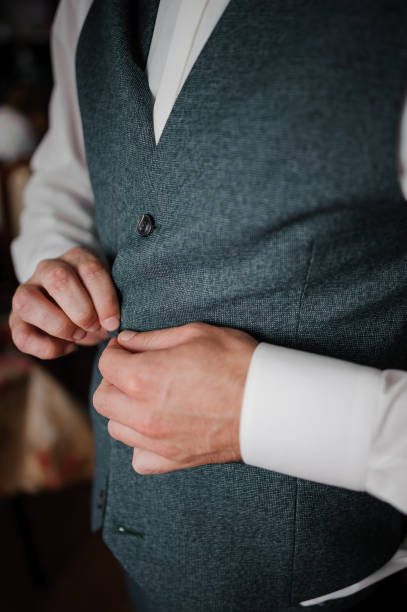 istock The man fasten a button on his jacket. The groom fasten a button on his jacket 1390674443