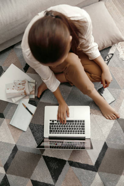 istock Closeup womans hands holding phone and working at laptop computer. Working at home 1390674823